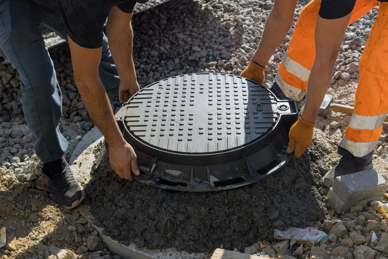Workers prepare to inspect a septic tank